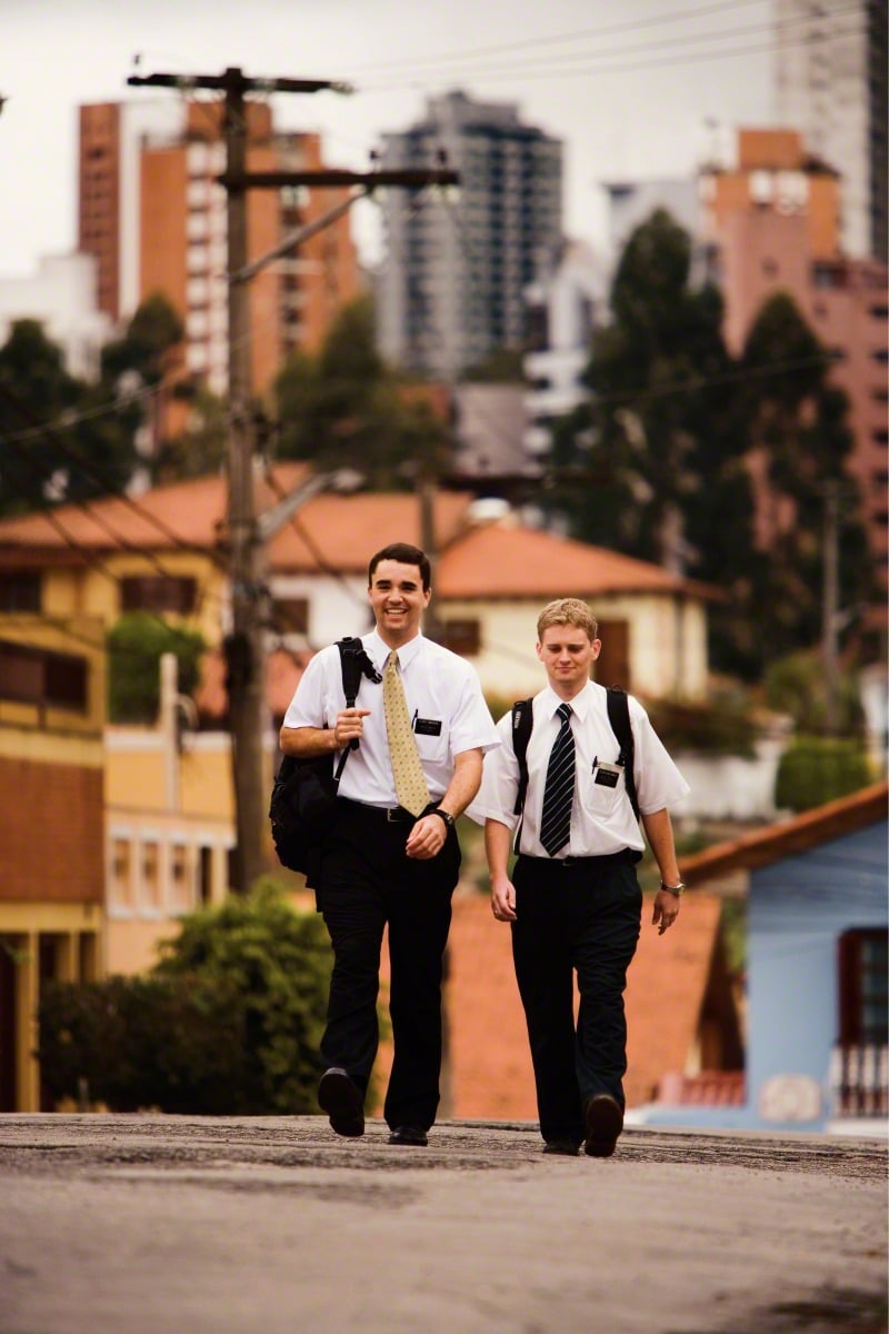 A man and a woman walking down a street in corporate uniform