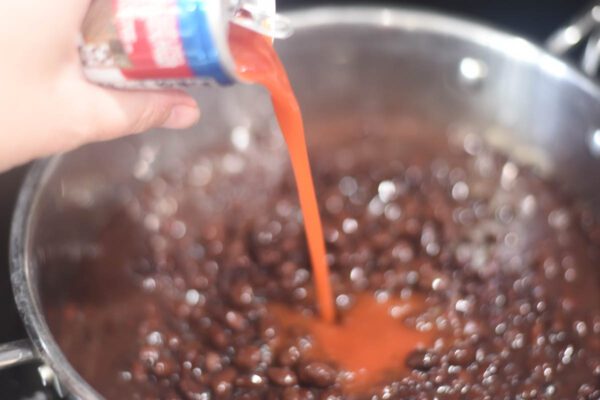 pouring tomato sauce into pan